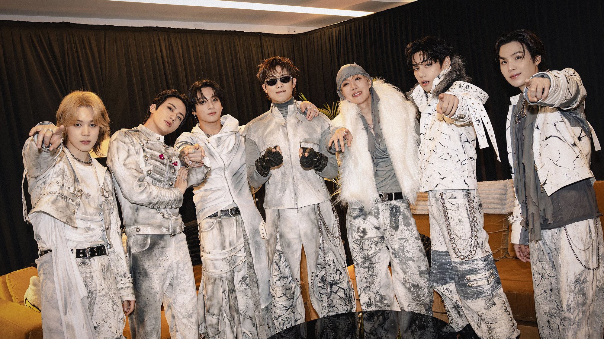 Tujuh member BTS berpose dengan kostum putih keperakan di belakang panggung konser Buenos Aires
