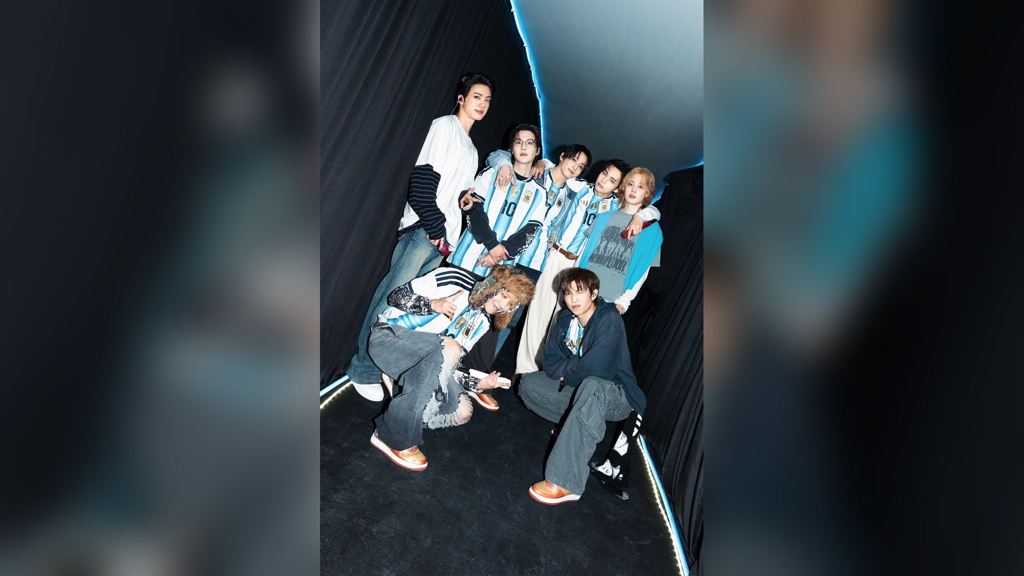 Member BTS mengenakan kaus bergaris biru muda dan putih di belakang panggung konser Buenos Aires