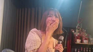 Chitose Saegusa memegang mikrofon saat acara penggemar 2025