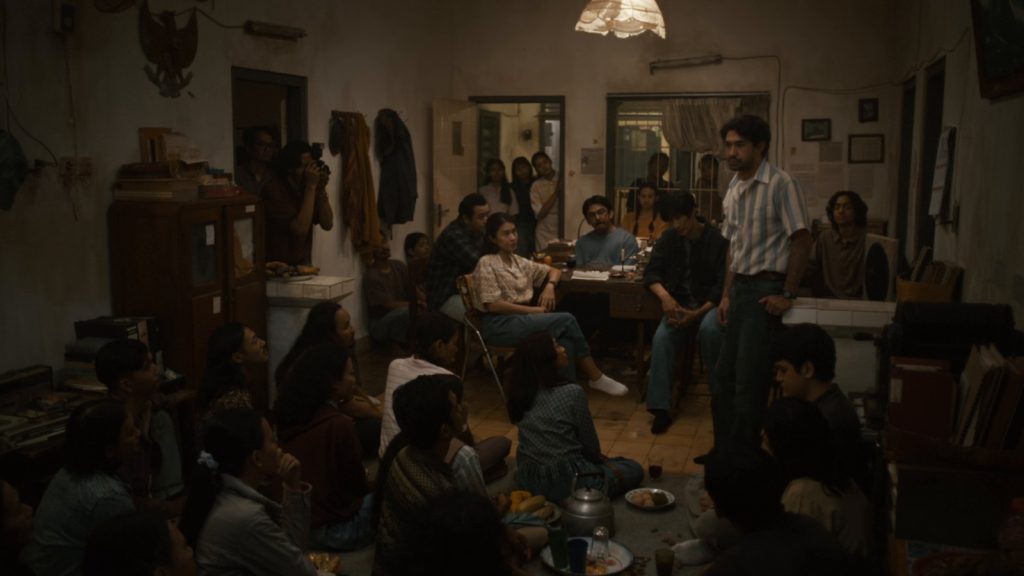 Anggota kelompok studi Winatra berdiskusi di sebuah rumah dalam film Laut Bercerita