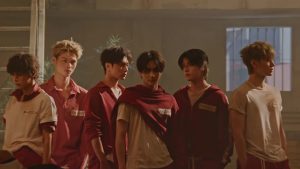 Member ENHYPEN berbaris dalam seragam merah di video musik Bloody Paradise