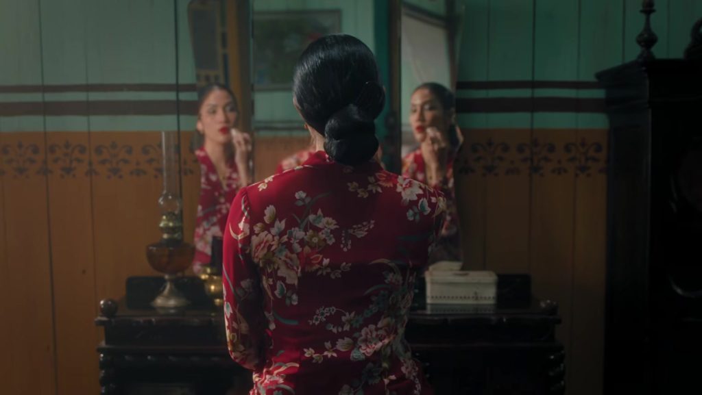 Film Pirunduk: Sinopsis, Pemain, dan Promo Tiket Rp25 Ribu 1 Perempuan berbaju merah bermotif bunga duduk di depan cermin dalam trailer film Pirunduk