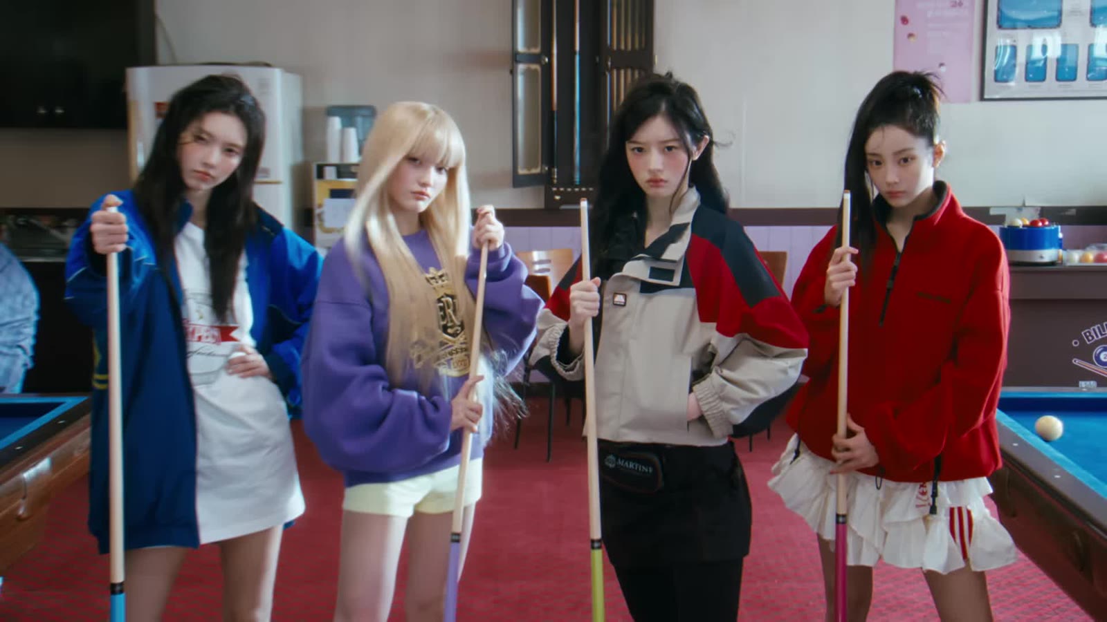 Empat member ILLIT memegang stik biliar dalam MV You're Under Arrest