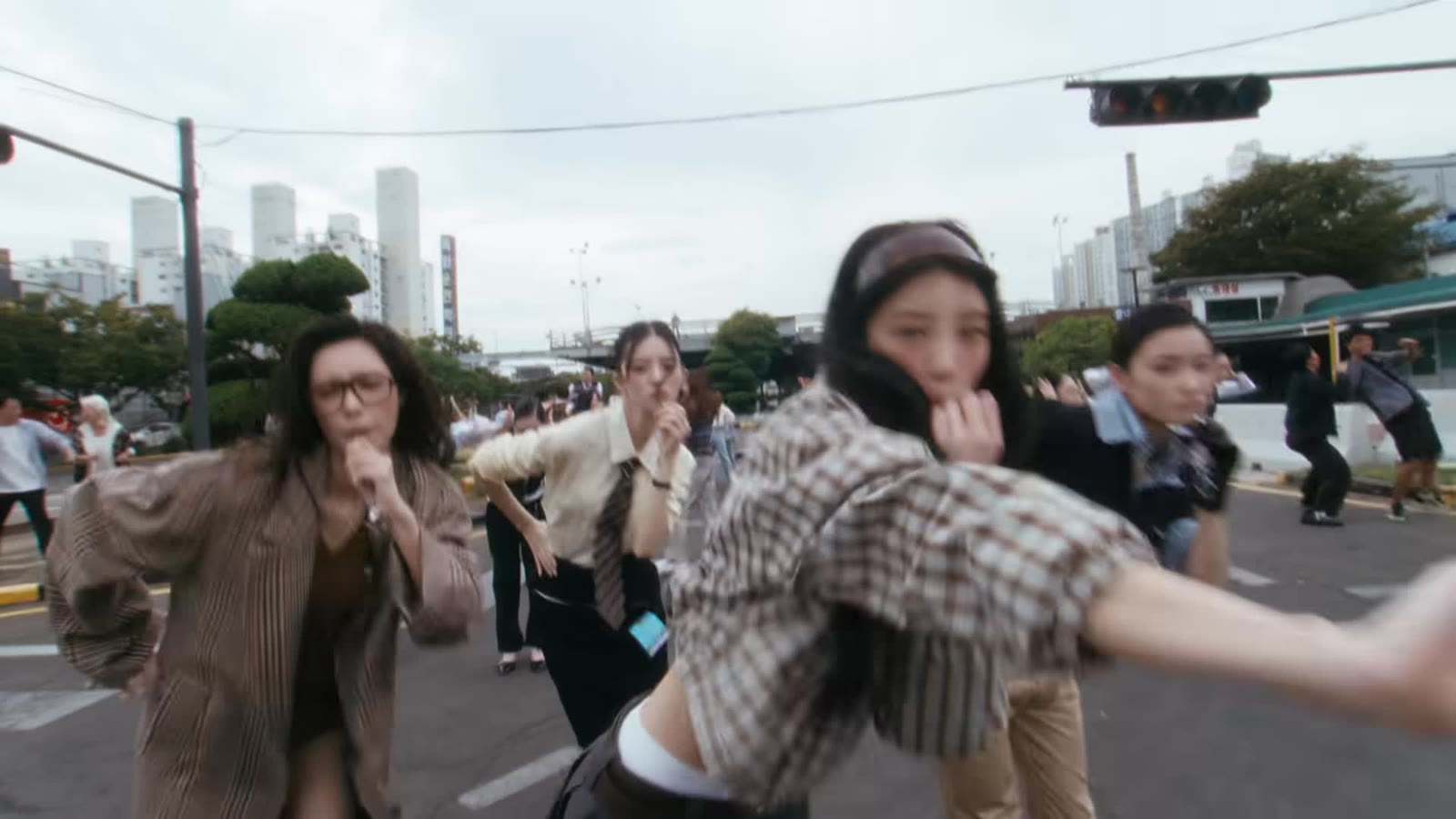 Member ILLIT menari koreografi You're Under Arrest di persimpangan jalan