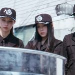 Tiga member ILLIT bertopi seragam agen dalam MV You're Under Arrest