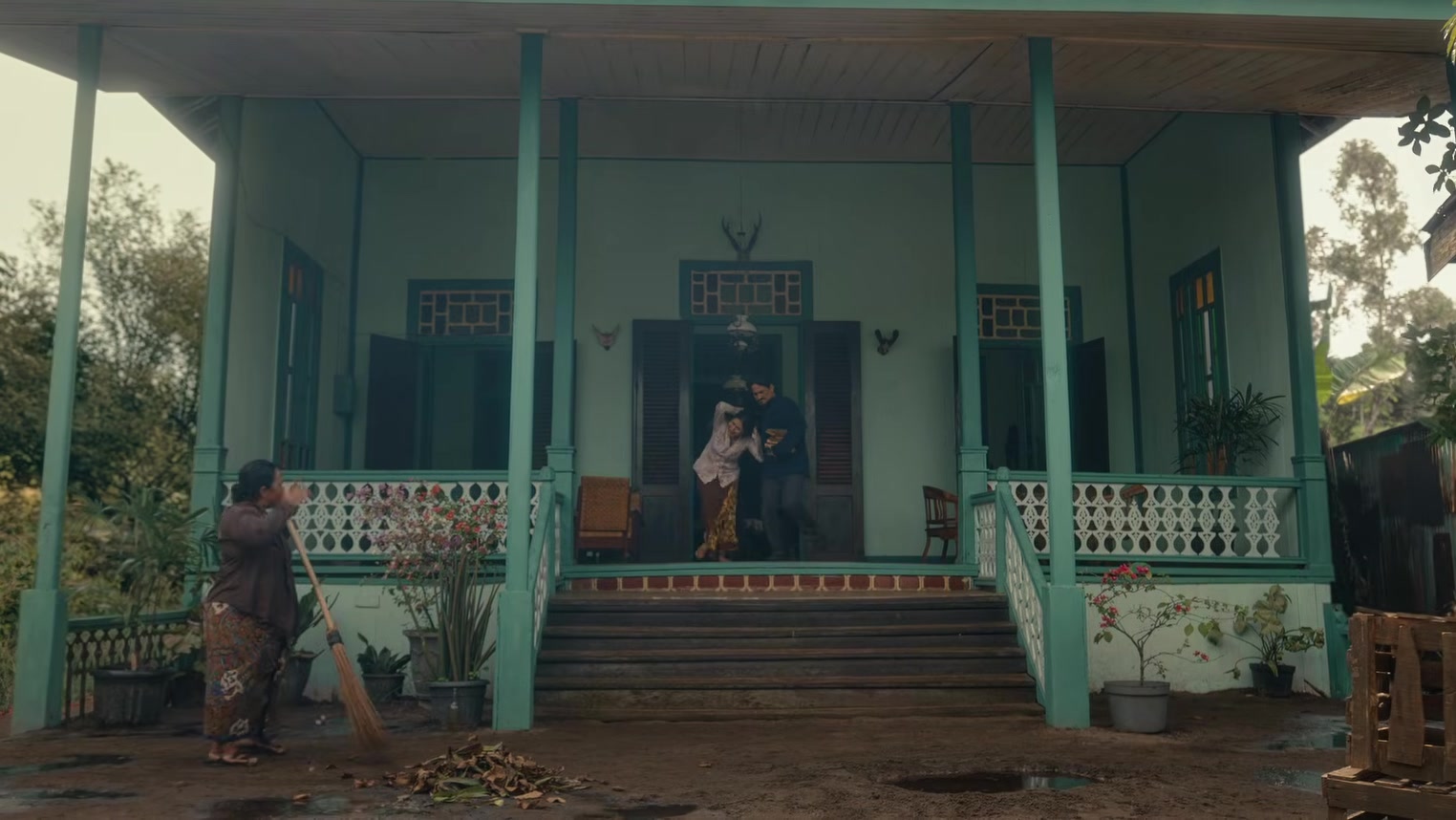 Film Pirunduk: Sinopsis, Pemain, dan Promo Tiket Rp25 Ribu 5 Rumah kayu bercat hijau dengan beranda dalam trailer film Pirunduk