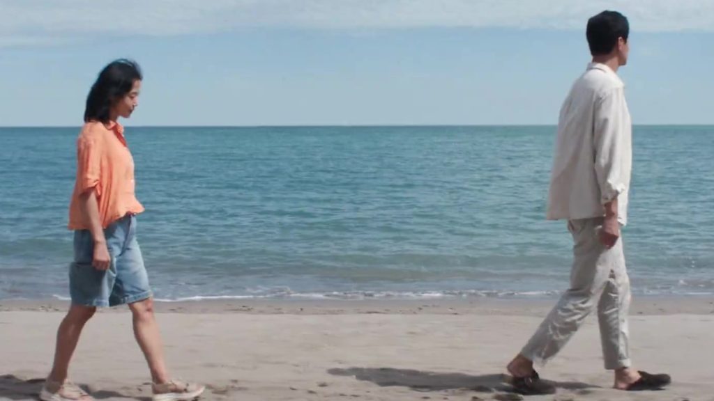 Dua tokoh film Possible Love berjalan di tepi pantai dalam trailer resmi Netflix