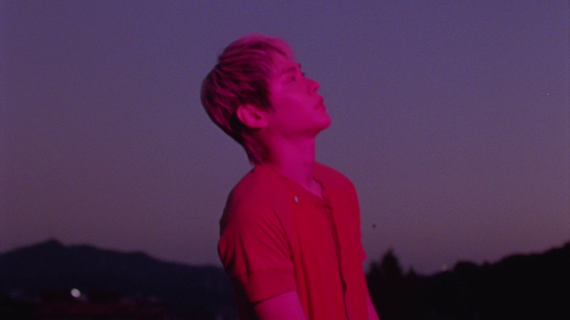 Member RIIZE menengadah ke langit senja dengan cahaya merah dalam teaser MV Insomnia