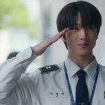 Jisung NCT sebagai Ji Dae-se memberi hormat dengan seragam polisi putih di video musik Smash It