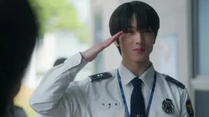 Jisung NCT sebagai Ji Dae-se memberi hormat dengan seragam polisi putih di video musik Smash It