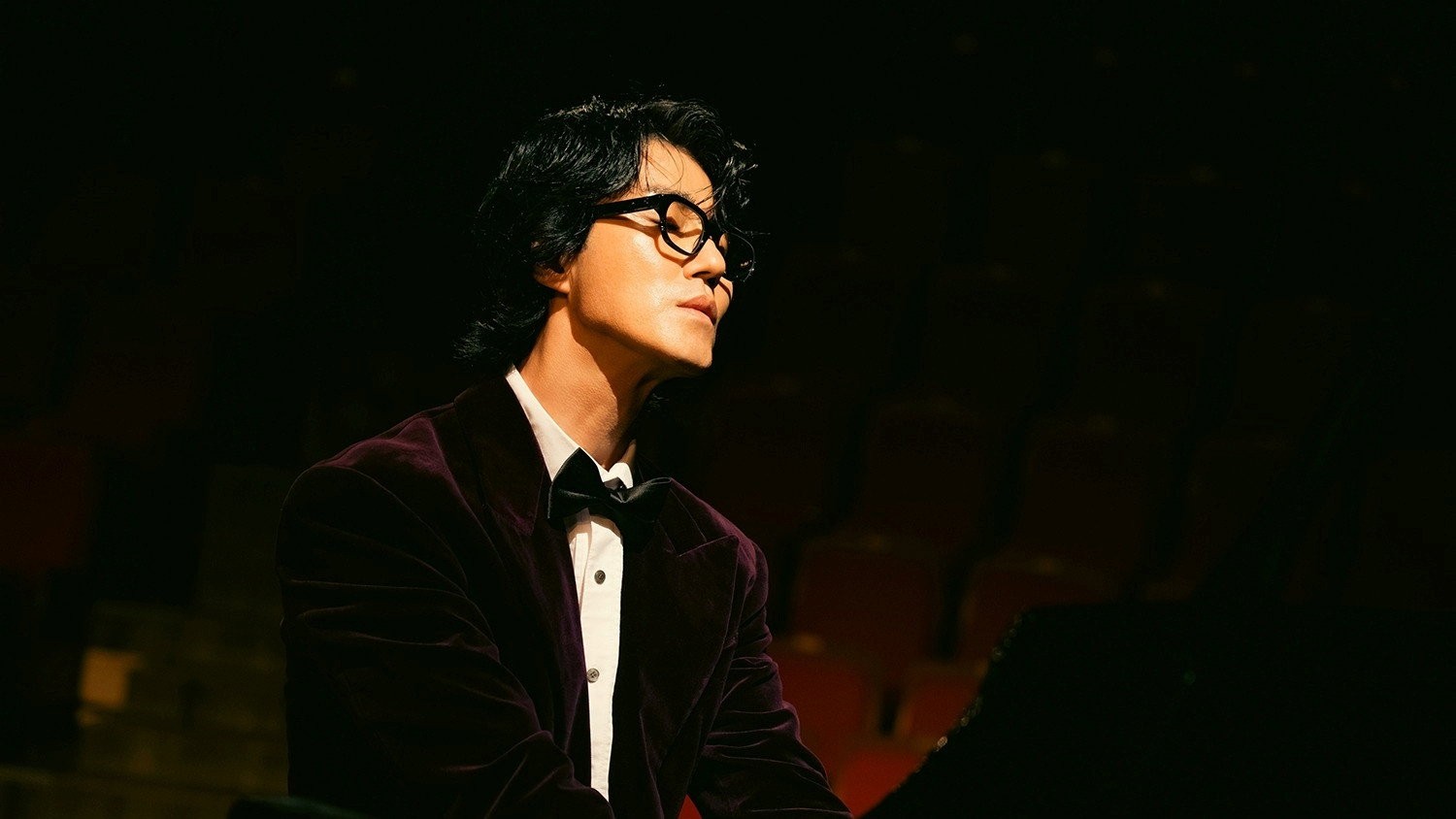 Cha Seung-won sebagai Gil-yeo berkacamata dan bertuksedo duduk di depan piano dalam serial Tantara